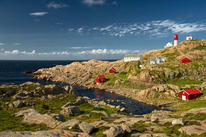 Rocky coast near Lindesnes with the lighthouse in the background