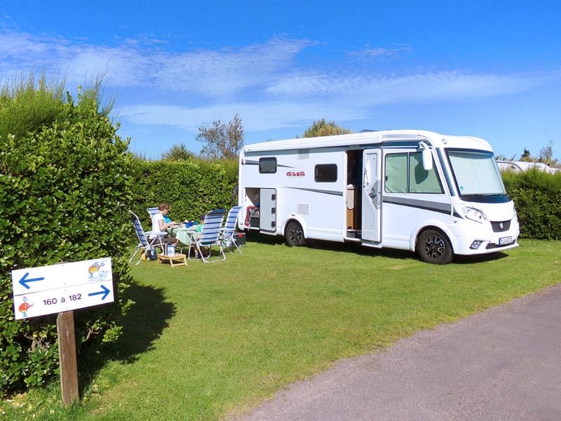 Motorhome with woman on garden set in front of it.