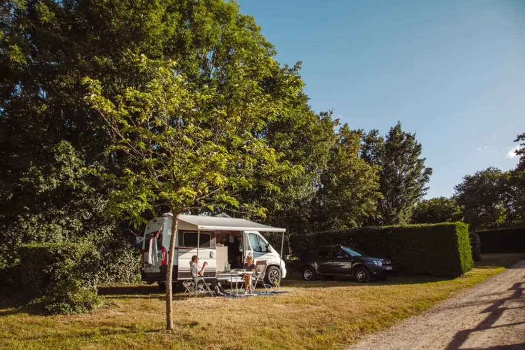 man and woman in front of motorhome Camping Village de la Guyonnière best motorhome pitches