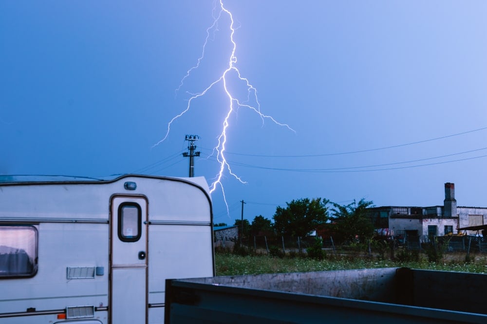 lightning strikes with a caravan in the foreground