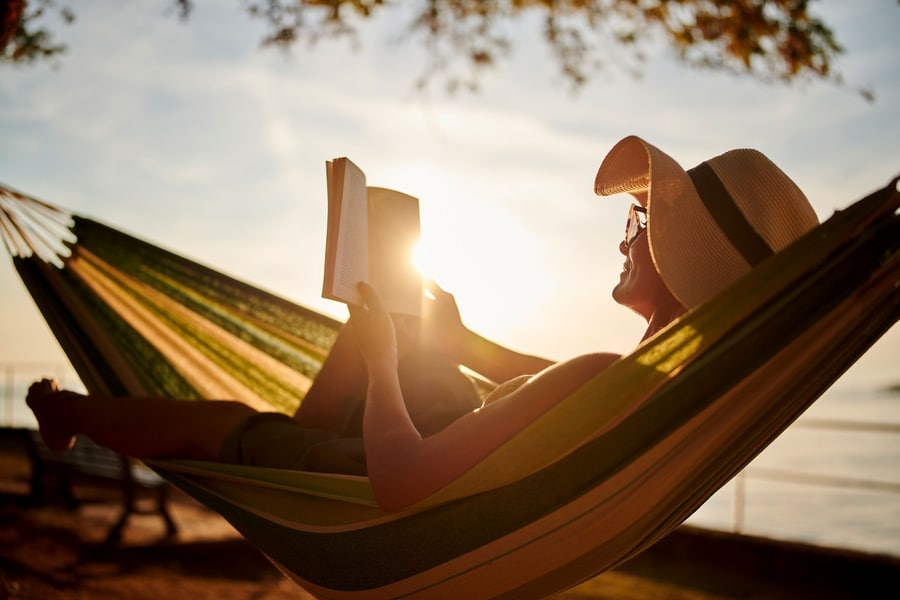 woman reading a book in a hammock